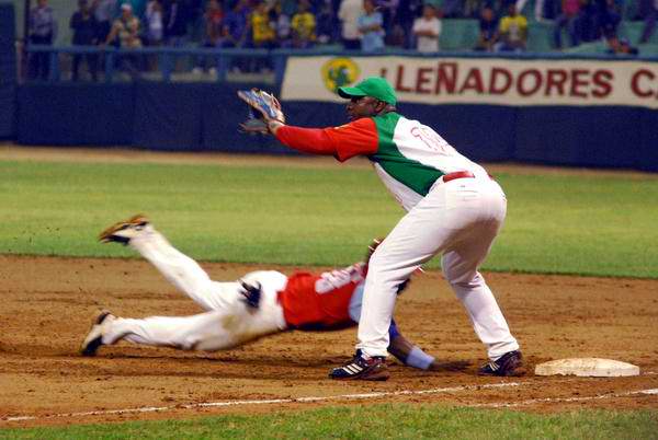 Los Leñadores (rojo y verde), de Las Tunas, y Los Tigres, de Ciego de Ávila, en el segundo juego de los play off de la 51 Serie Nacional de Béisbol, celebrado en el estadio Julio Antonio Mella, en Las Tunas, el 26 de abril de 2012. Foto: Yaciel Peña/AIN