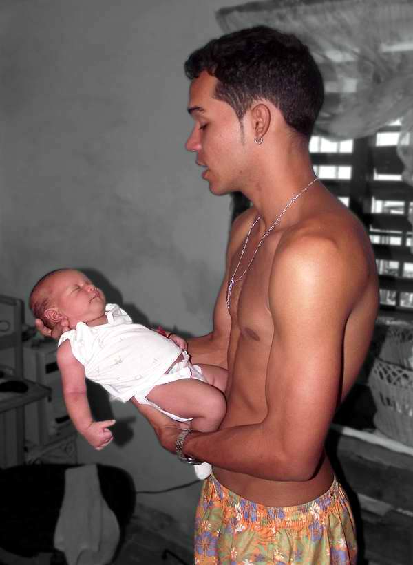 El bebé se siente protegido en los brazos de su padre El bebé se siente protegido en los brazos de su padre