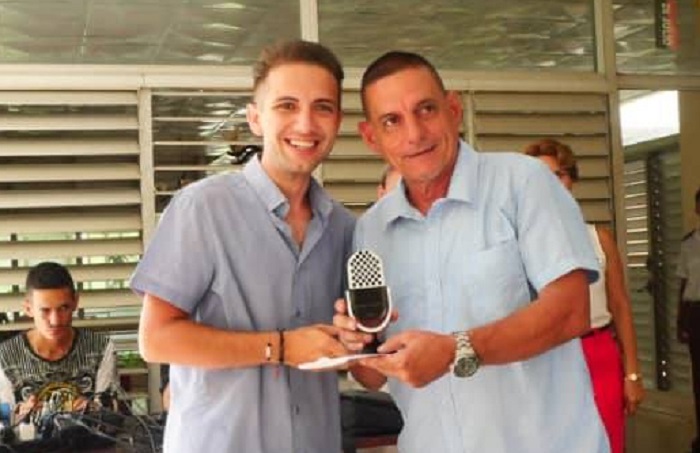 Juan Carlos Castellón recibe micrófono de la radio